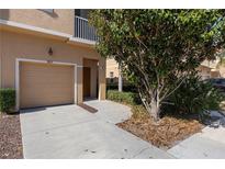 Tan colored townhome with attached garage and landscaping at 3815 Parkridge Cir # 2-203, Sarasota, FL 34243