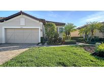 Charming single-Gathering home with a well-manicured lawn, a two-car garage, and a tile roof at 5846 Cavano Dr, Sarasota, FL 34231