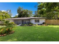 Charming single-story home featuring a lush green lawn and well-maintained landscaping under a clear blue sky at 671 47Th St, Sarasota, FL 34234