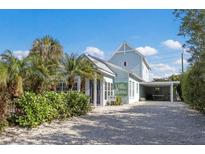 Charming light blue two-story home with a landscaped front yard and driveway at 307 Spring Ave, Anna Maria, FL 34216