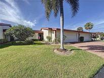 Exterior view of charming villa with 2-car garage, lush landscaping, and beautiful palm tree at 707 Sorrento Inlt # 707, Nokomis, FL 34275