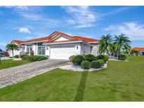 Single-story home with tile roof, landscaped yard, and two-car garage at 741 Fairway Ridge Ct, Sun City Center, FL 33573