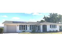 Charming single-story home featuring a well-maintained lawn, solar panels, and an attached garage at 2271 Sandlewood Dr, Venice, FL 34293