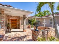 Inviting front entrance with brick accents, wooden door, fountain, and lush landscaping at 2605 Desoto Rd, Sarasota, FL 34234