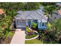 Beautiful home featuring a tile roof, lush landscaping, and a brick paved driveway at 3260 Bayou Rd, Longboat Key, FL 34228