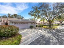 Two-car garage and driveway with manicured landscaping at 5436 Hampstead Heath # 25, Sarasota, FL 34235