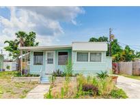 Light teal single-wide mobile home with porch and landscaped yard at 604 49Th Avenue W Dr, Bradenton, FL 34207