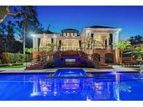 Luxury home backyard featuring a swimming pool, jacuzzi, and outdoor entertainment area under the covered patio at 1541 Bay Point Dr, Sarasota, FL 34236