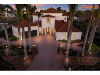 Stunning two-story home with red roof, circular driveway, and lush tropical landscaping at 367 W Royal Flamingo Dr, Sarasota, FL 34236