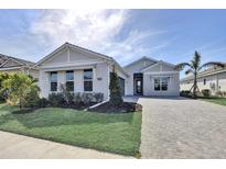 Charming single-story home with well-maintained landscaping and a paver driveway leading to the front entrance at 17920 Palmiste Dr, Bradenton, FL 34202