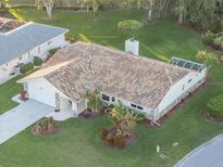 Charming home featuring a terra cotta roof, well-manicured lawn, and lush landscaping at 1726 Killdeer Cir, Venice, FL 34293