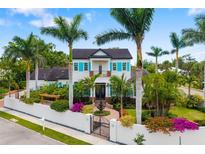 Stunning two-story home with lush landscaping, a charming fountain, and turquoise shutters at 1810 Lincoln Dr, Sarasota, FL 34236