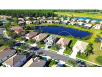 Aerial view of a charming single-Gathering home in a waterfront community with lush landscaping and mature trees at 236 Golden Harbour Trl, Bradenton, FL 34212