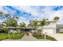 Charming two-story home featuring a well-manicured lawn with beautiful palm trees at 3348 S Seclusion Dr, Sarasota, FL 34239
