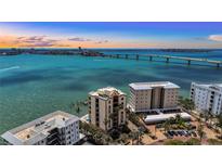 Stunning aerial view of a beachfront property with ocean views and a bridge in the background at 378 Golden Gate Pt # 6, Sarasota, FL 34236