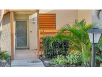 Inviting front entrance with a gray door, lush landscaping, and clear unit number at 144 Wild Palm Dr, Bradenton, FL 34210