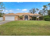Charming one-story home featuring a well-manicured lawn, two-car garage, and neutral color palette at 1577 Taggard Rd, North Port, FL 34288