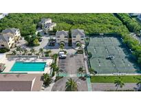 Aerial view of beach condos near a pool, tennis courts and lots of parking at 653 Cedars Ct, Longboat Key, FL 34228