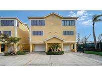 Charming, yellow, multi-story townhouse with a two-car garage in a desirable location at 653 Cedars Ct, Longboat Key, FL 34228