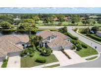 Beautiful home featuring a tiled roof, lush landscaping, a three-car garage, and stunning golf course views at 8737 Pebble Creek Ln, Sarasota, FL 34238