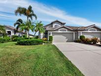 Charming home with a well-manicured lawn, beautiful landscaping, and a multi-car garage at 8737 Pebble Creek Ln, Sarasota, FL 34238