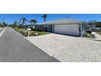 Charming waterfront home with circular paver driveway and mature landscaping at 618 Jungle Queen Way, Longboat Key, FL 34228