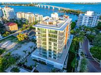 Stunning aerial view of the modern condo building with bay and bridge views at 111 Golden Gate Pt # 401, Sarasota, FL 34236