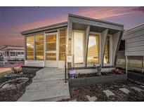 Charming single-story home featuring a glass-enclosed porch and modern architectural details at 4851 W Gandy Blvd # B1L8, Tampa, FL 33611