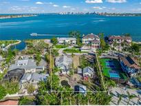 Breathtaking waterfront property with lush landscaping, mature trees, and an in-ground pond at 624 Norsota Way, Sarasota, FL 34242
