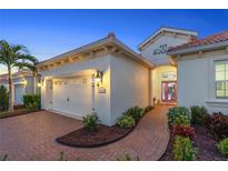 Charming home featuring a tile roof, brick driveway, and well-manicured landscaping at 11816 Altamonte Ct, Venice, FL 34293