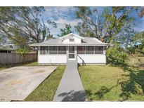 Charming home with a screened front porch, mature trees, and a well-maintained front lawn at 1717 32Nd St, Sarasota, FL 34234