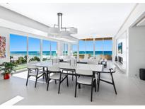 Bright dining area with ocean views, a modern chandelier, and ample seating for sophisticated dining and entertaining at 6100 Midnight Pass Rd # 401, Sarasota, FL 34242