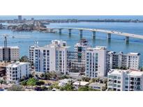 Stunning aerial view of waterfront condos with bridge and bay, showcasing luxurious coastal living at 223 Golden Gate Point # 2A, Sarasota, FL 34236