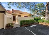 Well-maintained exterior with a tile roof, manicured landscaping, and a gated front entrance at 5343 Huntingwood Ct # 33, Sarasota, FL 34235