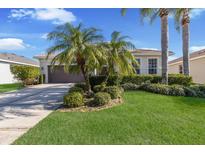 Beautiful home featuring a well-manicured front lawn and mature palm trees enhancing curb appeal at 6914 45Th E Ter, Bradenton, FL 34203