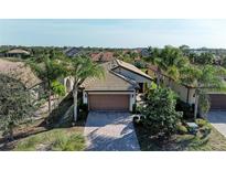Charming single-story home with a well-manicured lawn, palm trees, and a brick driveway at 6739 Haverhill Ct, Lakewood Ranch, FL 34202