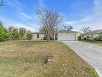 Charming single-story home with a well-maintained lawn and a two-car garage at 1382 Ronald St, North Port, FL 34286