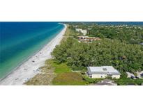Beautiful aerial view of the beach and condos surrounded by lush landscaping and turquoise water at 5311 Gulf Of Mexico Dr # 3, Longboat Key, FL 34228