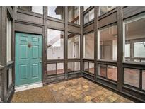 Inviting entryway with a modern, aqua-colored front door and multi-paned windows for ample natural light at 800 S Blvd Of Presidents # 12, Sarasota, FL 34236