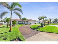 Charming single-story home with lush green lawn, swaying palm trees, and a driveway, creating curb appeal at 829 Harbor S Dr, Venice, FL 34285