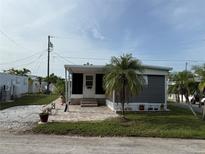 Charming single-story home with a screened-in porch, brick patio, and lush green lawn at 2601 Gulf N Dr # S2, Bradenton Beach, FL 34217