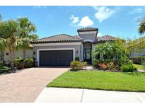 Charming single-Gathering home featuring a tile roof, well-maintained landscaping, and an attached two-car garage at 4020 Cascina Way, Sarasota, FL 34238