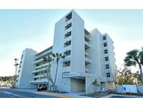 Contemporary condominium building with multiple floors, balconies, and tropical landscaping at 240 Sands Point Rd # 4201, Longboat Key, FL 34228