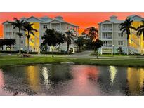 Beautiful condos with balconies overlook a serene lake, palm trees, and manicured lawns at sunset at 3430 77Th W St # 102, Bradenton, FL 34209