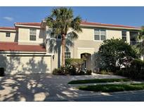 Beautiful two-story home featuring a two-car garage, a red tile roof and lush tropical landscaping at 9606 Sea Turtle Ter # 101, Bradenton, FL 34212