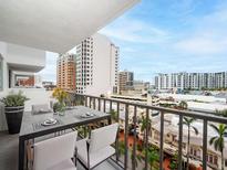 A condo balcony features a table set for dinner and city views at 101 S Gulfstream Ave # 10E, Sarasota, FL 34236