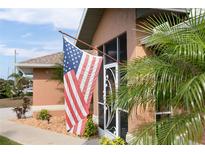 A welcoming entrance with an American flag flying high and a decorative screen door adds charm to the property at 2720 S Biscayne Dr, North Port, FL 34287