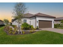 Well-maintained home with a tiled roof, lush lawn, and manicured landscaping at 16127 Fortezza Dr, Bradenton, FL 34211