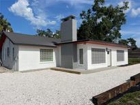 Modern white home with a gray roof, chimney, and stylish block windows on a sunny day at 4122 N Lockwood Ridge Rd, Sarasota, FL 34234