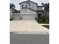 Charming two-story home with a three-car garage and well-manicured landscaping at 16154 Monterey Greens Cir, Tampa, FL 33647